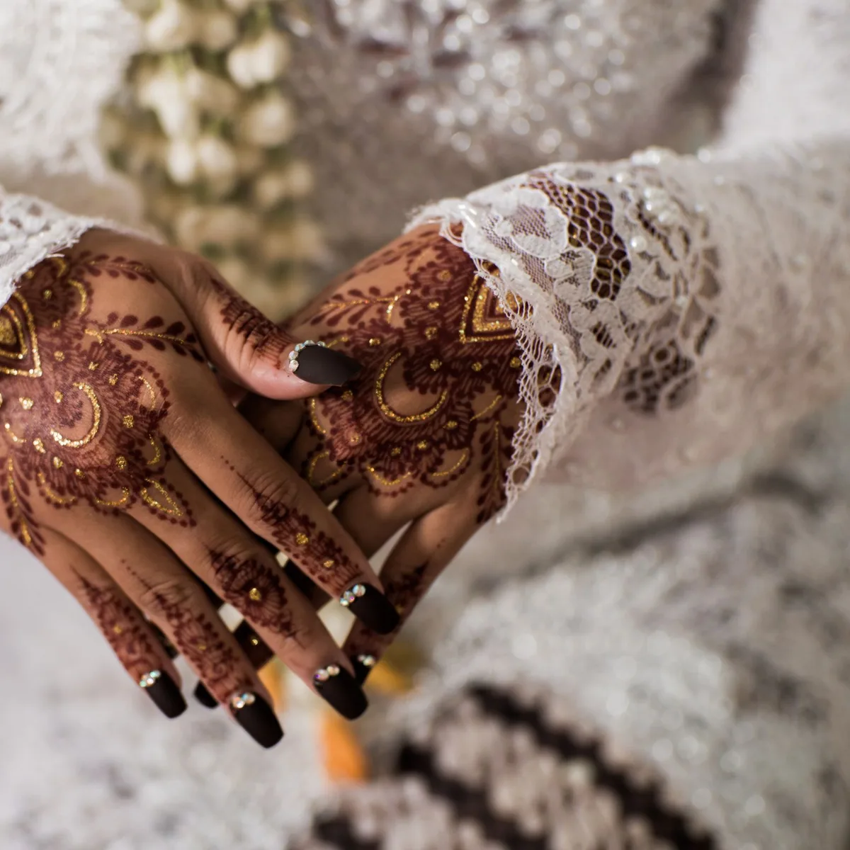 Mehndi function makeup look alongside freshly applied henna on the bride's hands